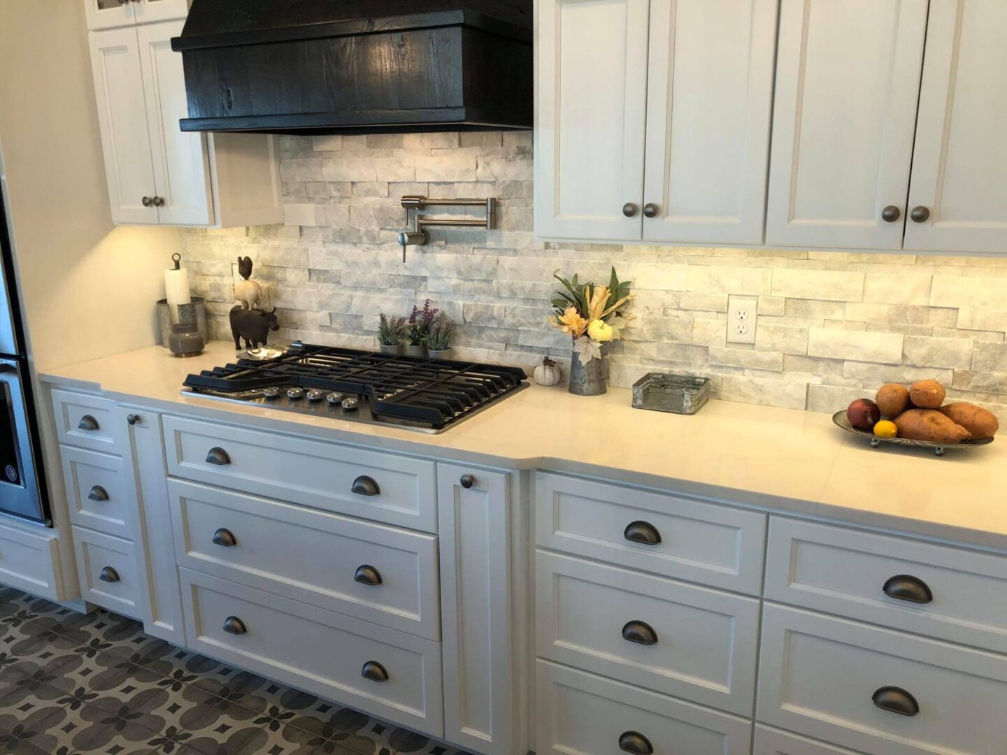 White kitchen cabinetry on light gray brick wall