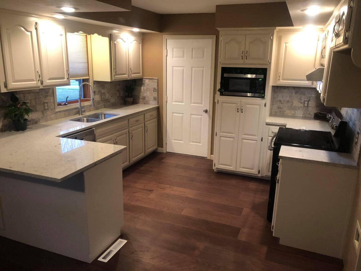 A kitchen with white cabinetry, walls, and countertops