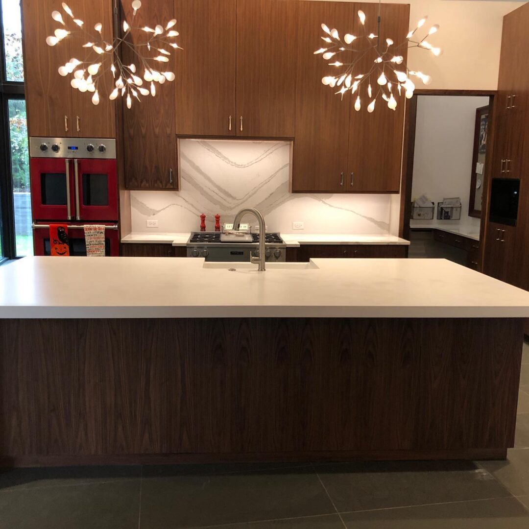 A kitchen with white walls and countertops and wooden cabinets